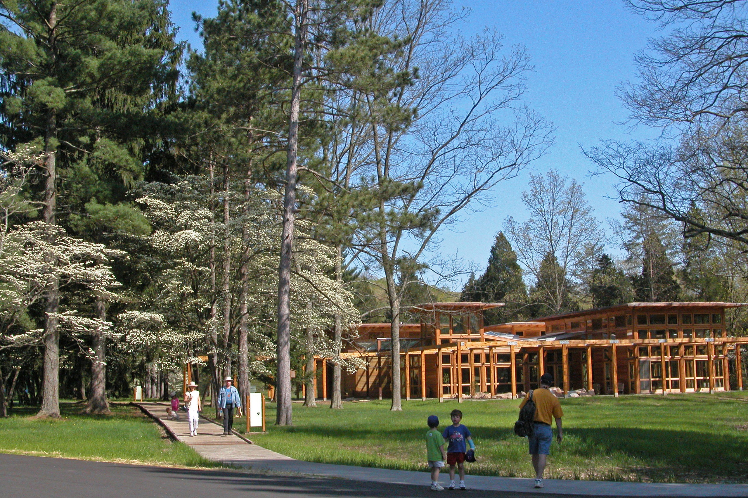 People in the foreground walking around Welcome Center at Bernheim Forest