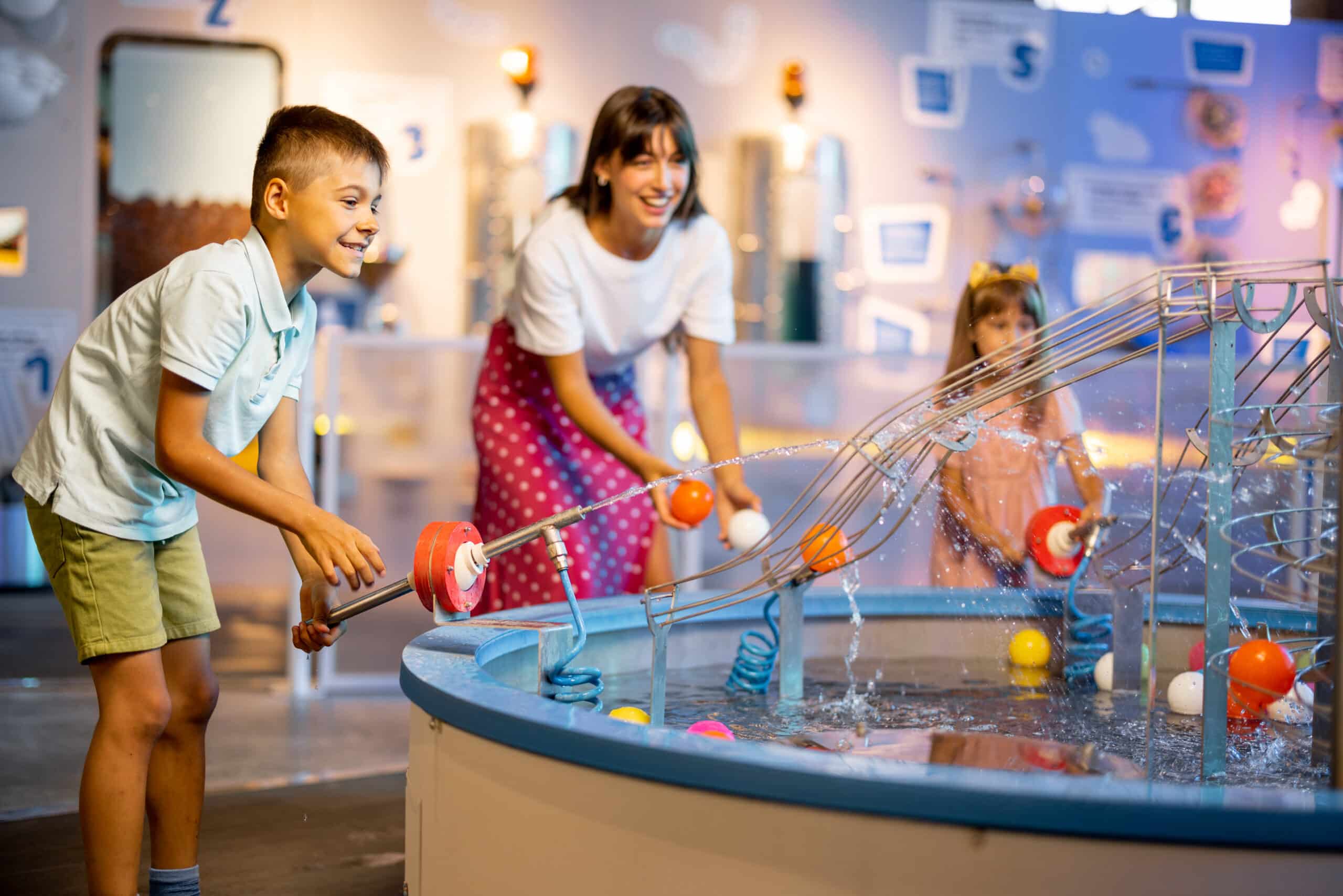 Mom with kids playing in a science museum